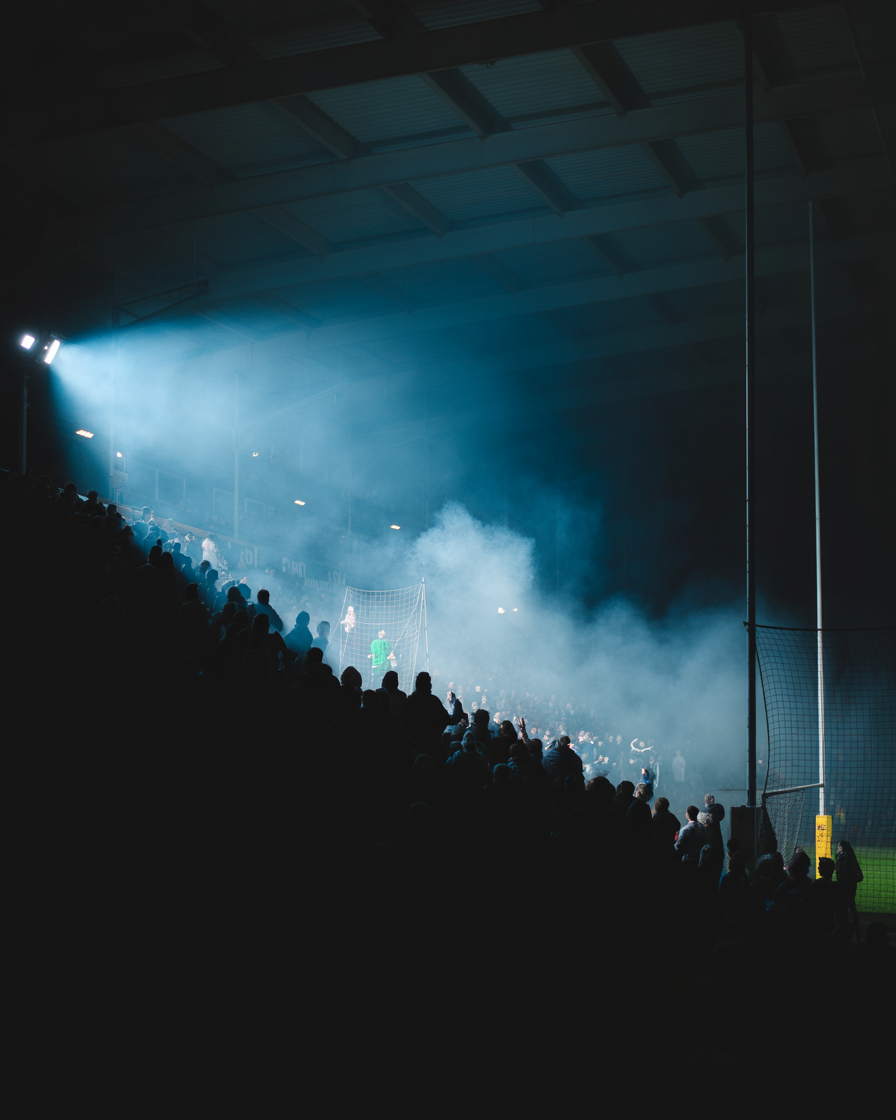 Rugby terrace silhouettes in cold spotlight mist
